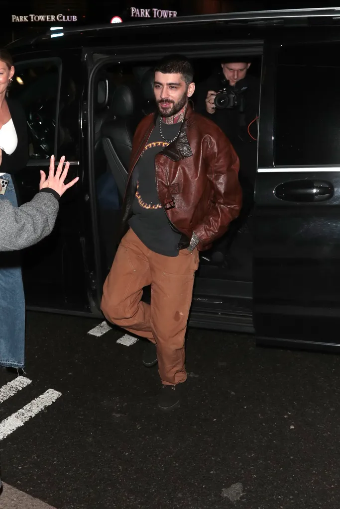 Zayn Malik stepping out of a black vehicle.