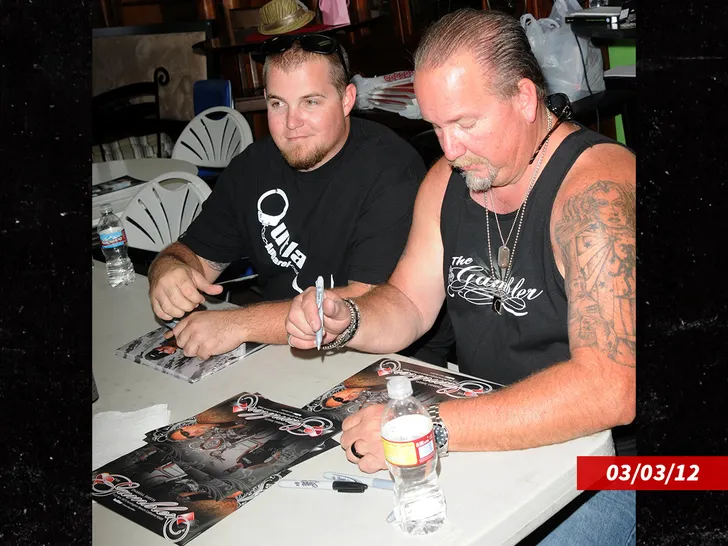 Darrell and Brandon Sheets seated at a signing table, smiling for fans.