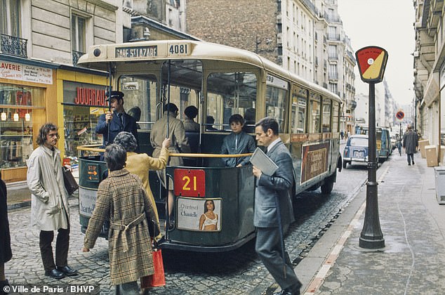 Tiny tin bus collecting locals along a cobbled Paris street