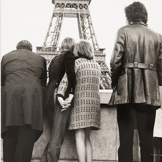 A newly-wed couple hold hands while taking in the sight of Paris's famous Eiffel tower - Daily Mail US