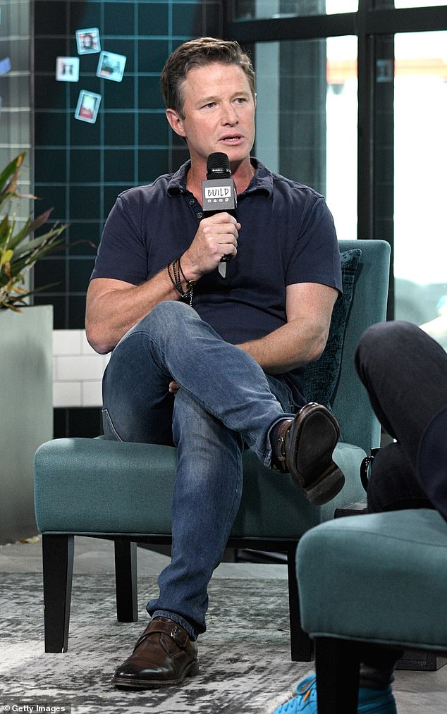 Billy Bush speaking into a microphone during an interview