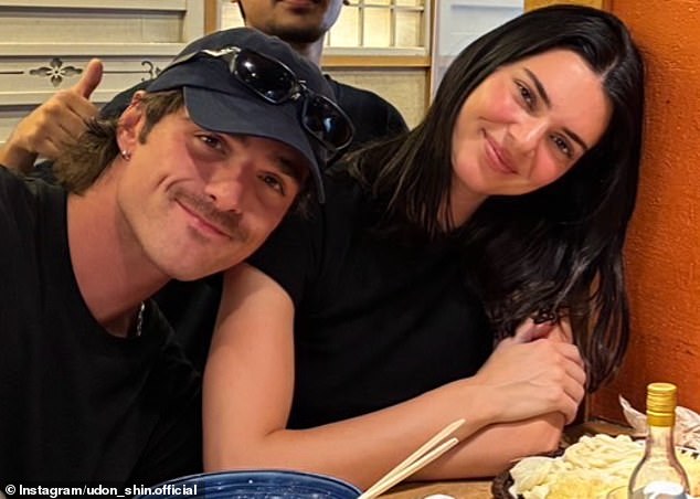 Kendall Jenner smiles in a chic black outfit as Jacob Elordi leans on her shoulder during a cozy dinner in Tokyo.