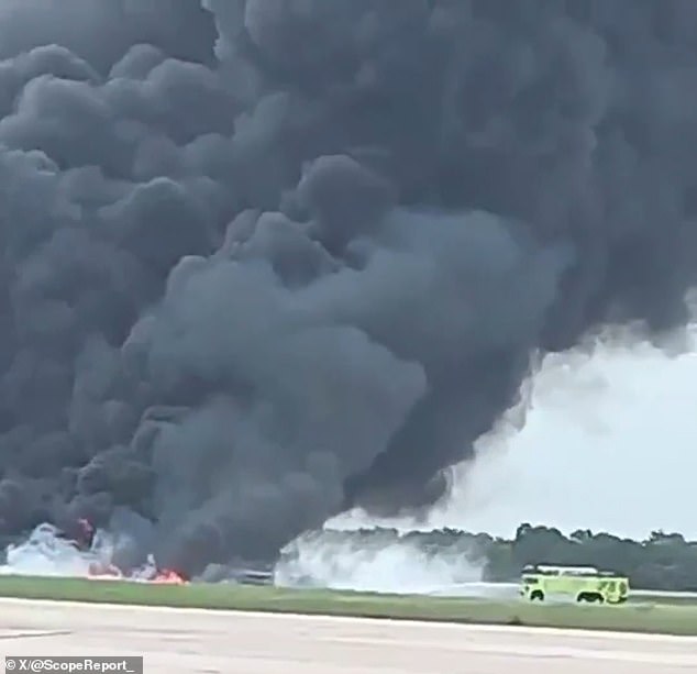 Thick black smoke rises from the crash site at La Romana International Airport as emergency crews respond.