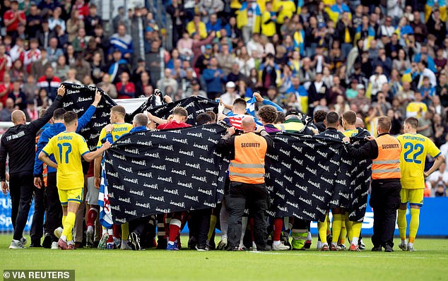 Players and staff shield Denmark's Christian Eriksen after he collapsed again mid-match yesterday