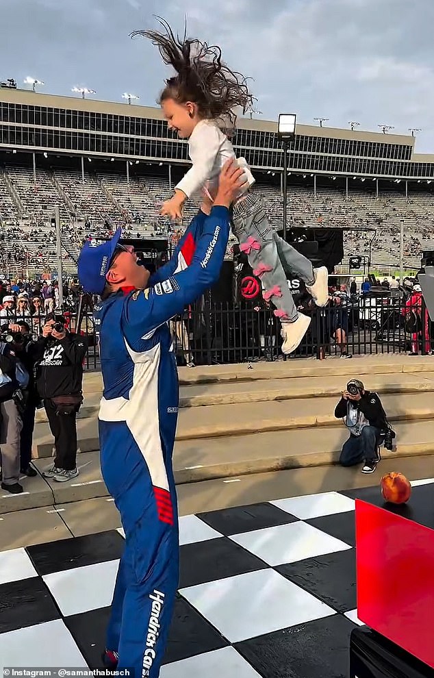 Kyle Busch celebrating with one of his children at the racetrack