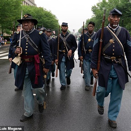The host argued that 'America has never actually fully reckoned with its racist past. Pictured, participants dressed in civil war Union Army uniforms march during a parade in Washington for Memorial Day last Monday - Daily Mail