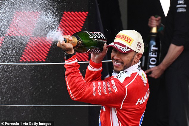 Lewis Hamilton celebrates on the Monaco podium, spraying champagne after finishing second.