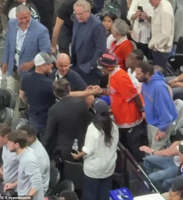 Prince Harry places a hand on Spike Lee's chest before reaching across for a brief handshake courtside during the NBA Finals.