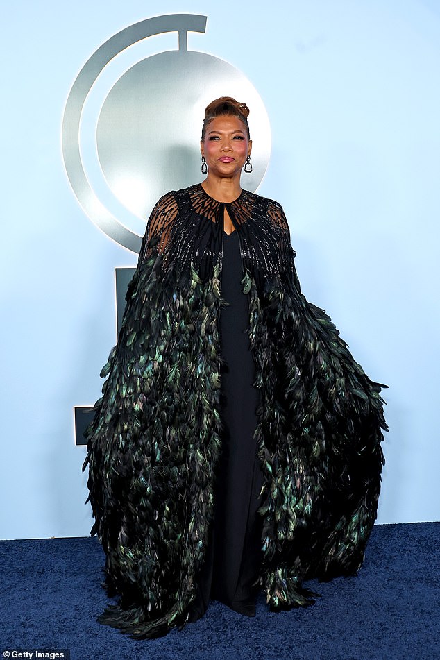 Queen Latifah commands the carpet in a dark green feathered Naeem Khan cape.