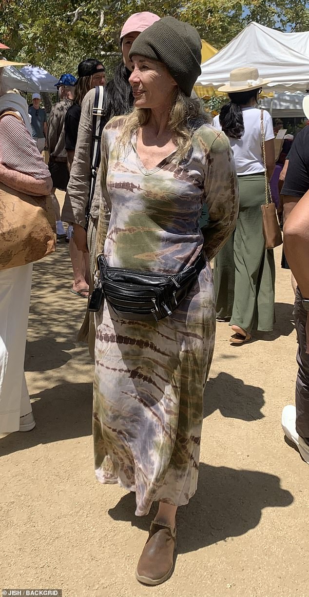 Mary Crosby, 66, in a patterned dress and green beanie carrying a tote at the Malibu Farmer's Market.