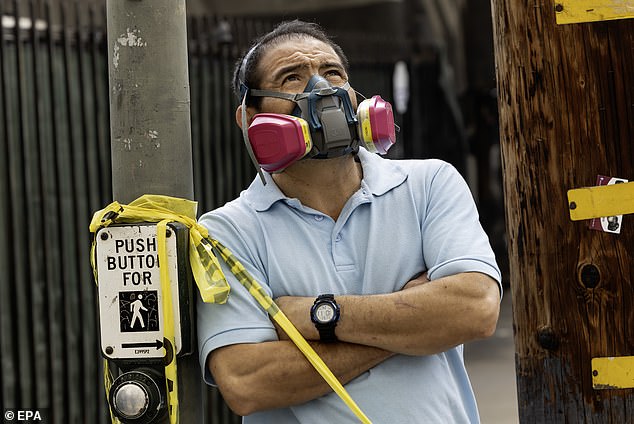 Residents watch as firefighters battle the huge Boyle Heights blaze; masks at the ready