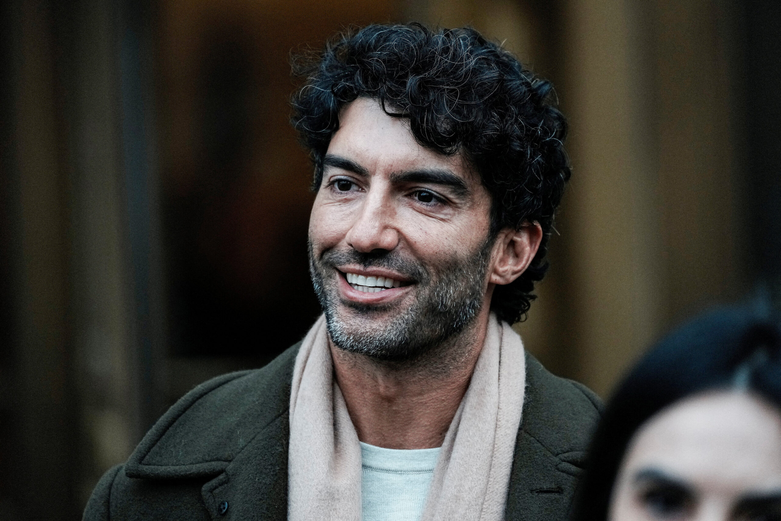 Justin Baldoni leaving a courthouse wearing a scarf and coat