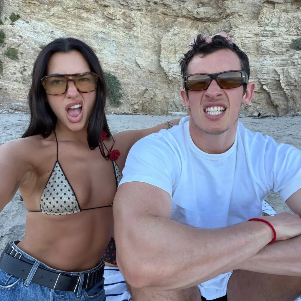 Dua Lipa and Callum Turner share a playful beach selfie.