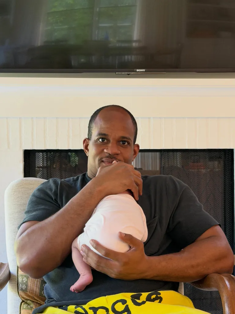 Geoffrey Ogunlesi holding his newborn daughter in a Father's Day Instagram photo.