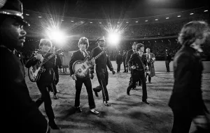 The Beatles walk toward the stage lights at Candlestick Park, 1966